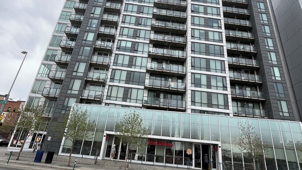 Un edificio moderno de rascacielos con varios balcones y fachada de vidrio.