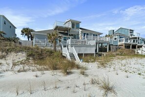 A beachfront property with a multi-level house, a staircase leading to a deck, and a sandy beach in the foreground. - Renovated beachfront retreat within walking distance to three outstanding restaurants! Fall asleep to the sounds of crashing waves on the beautiful Northeast Coast of Florida, just 5 miles from America’s oldest city, St. Augustine! (St. Augustine)
