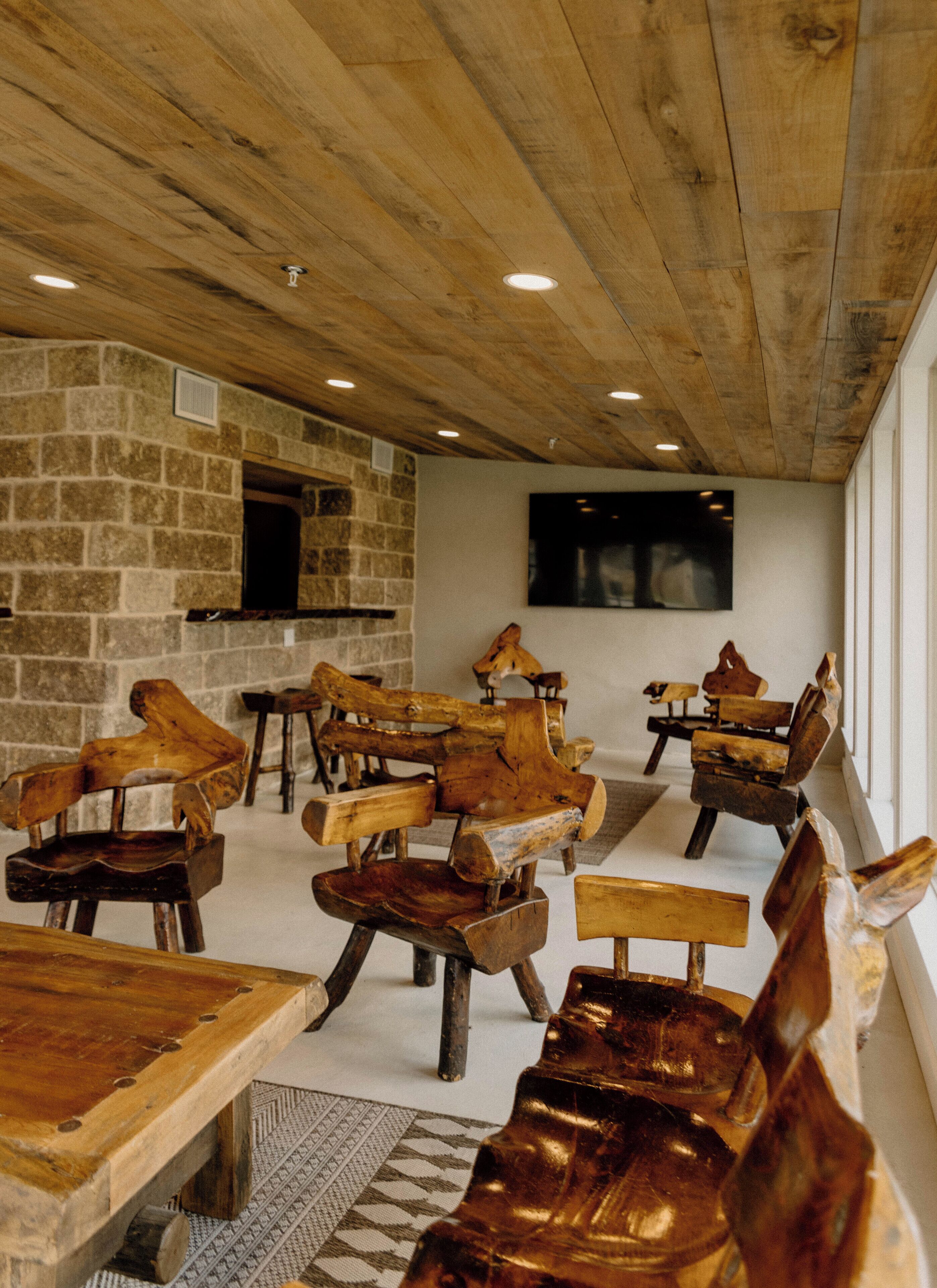 A rustic interior with wooden furniture and a stone wall.