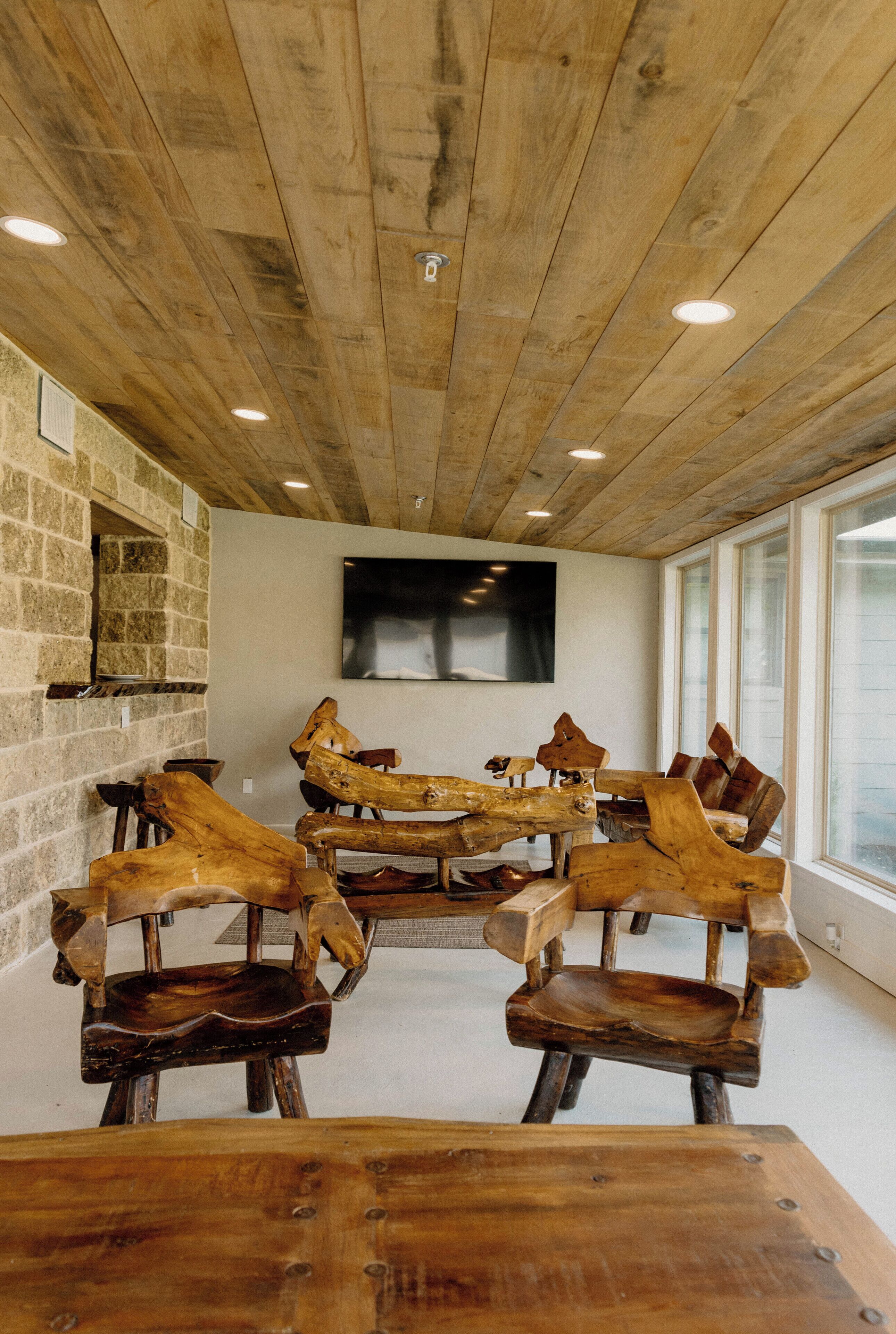 Ein rustikales Interieur mit Holzbalken, einer Steinwand und einem großen Fenster.