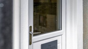 A white door with a glass panel and a nameplate reading "The Bruce's Quarter". - The Bruce's Quarter by The Wallace Monument (Stirling)