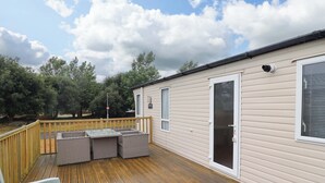 A wooden deck with outdoor furniture, a sliding glass door, and a sign indicating a private area.