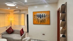 A modern living room with a marble floor, a sofa, a coffee table, and a painting on the wall.