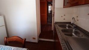 Una cocina con dos fregaderos, armarios de madera y salpicadero de azulejos.