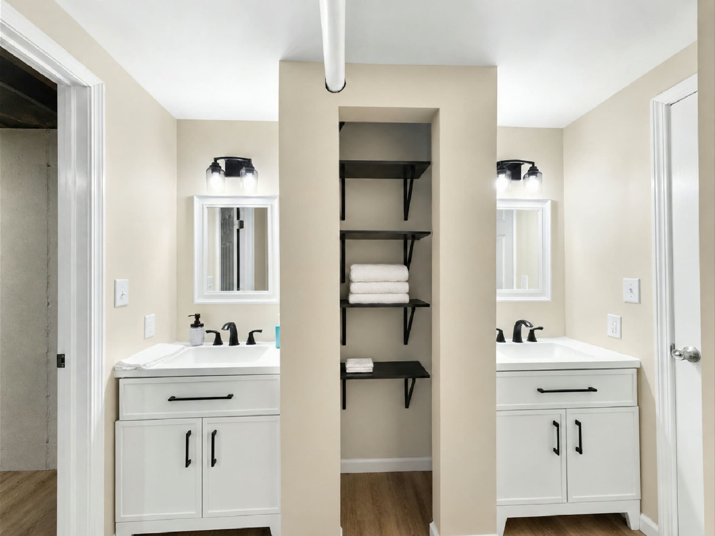 Enjoy the convenience of a spacious lower-level bathroom featuring two separate vanities, individual mirrors, modern fixtures, and plenty of room for multiple guests to get ready comfortably.