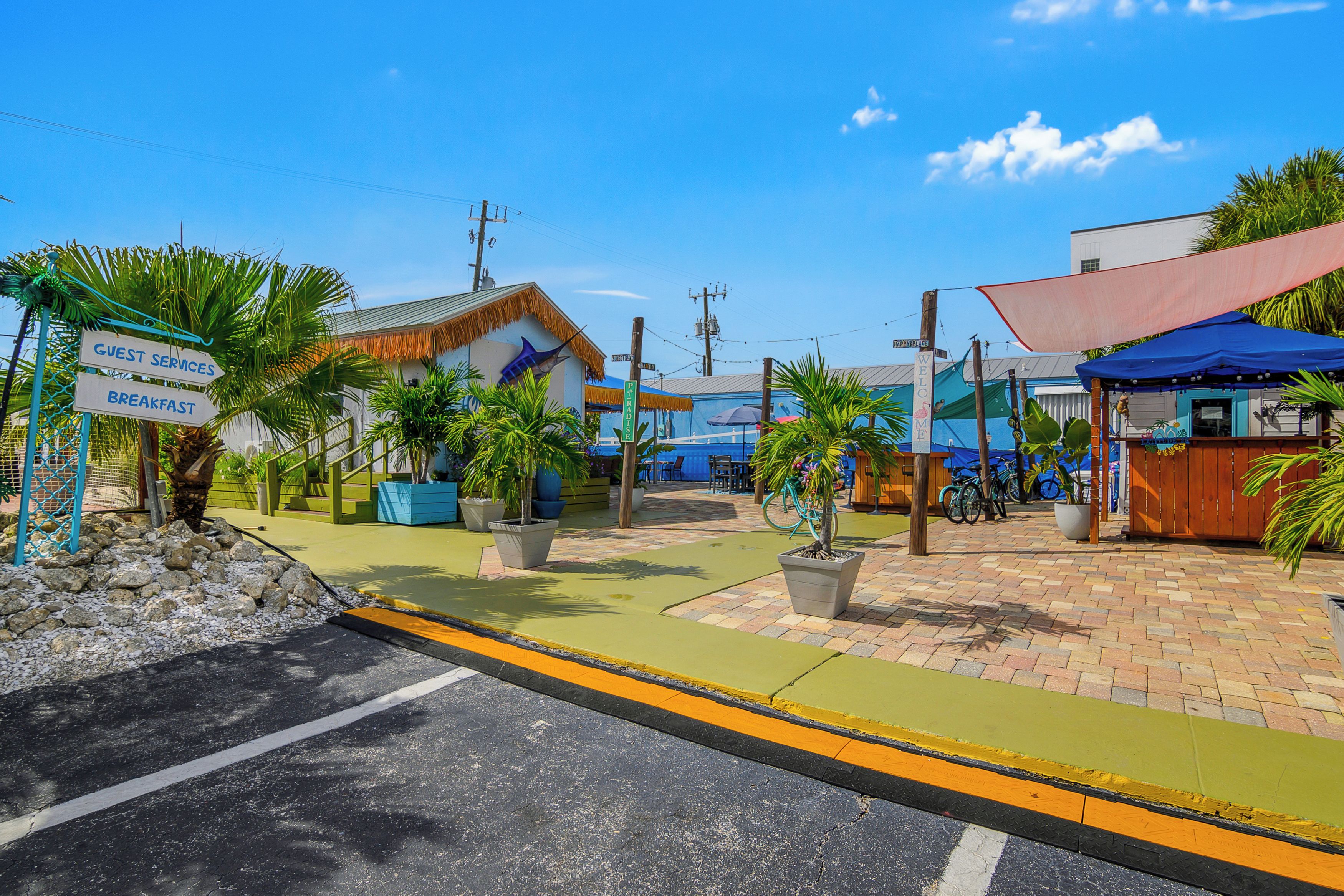 Un complexe hôtelier tropical doté d’un panneau d’information pour les clients, d’un panneau d’accueil et d’un restaurant appelé « PIRADISE ».