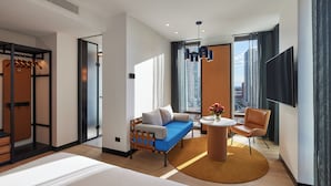 Una moderna camera d'hotel con un letto, un divano, un tavolino e una televisione.