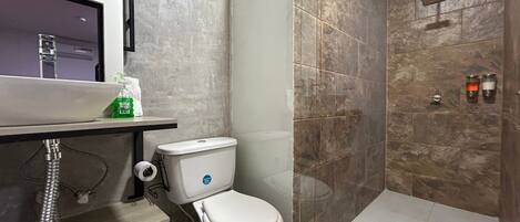 Un baño moderno con inodoro, lavabo y zona de ducha.