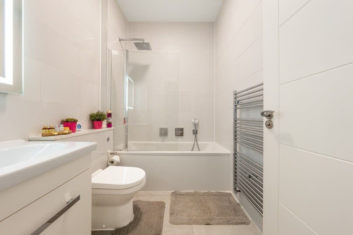 Un baño moderno con bañera, inodoro y zona de ducha.