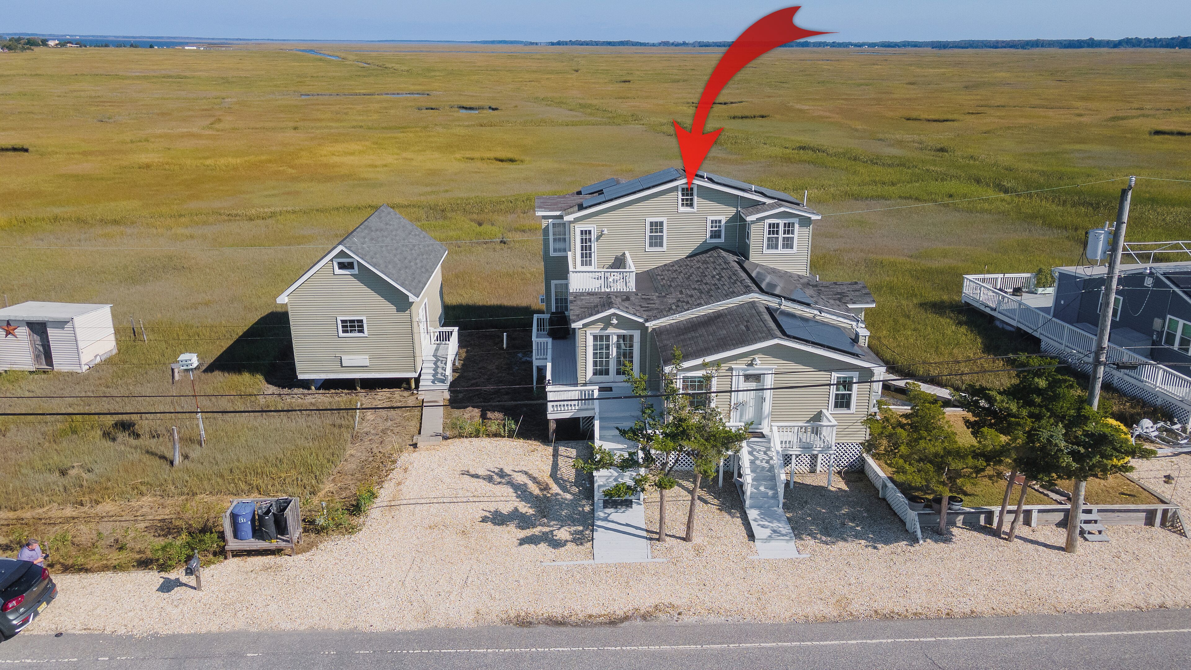 A two-story house with a balcony and a solar panel on the roof.