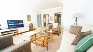 A modern living room with a flat-screen TV, a glass coffee table, and a sofa. - Havre de Paix Apt en Plein Centre de la Marsa (La Marsa)