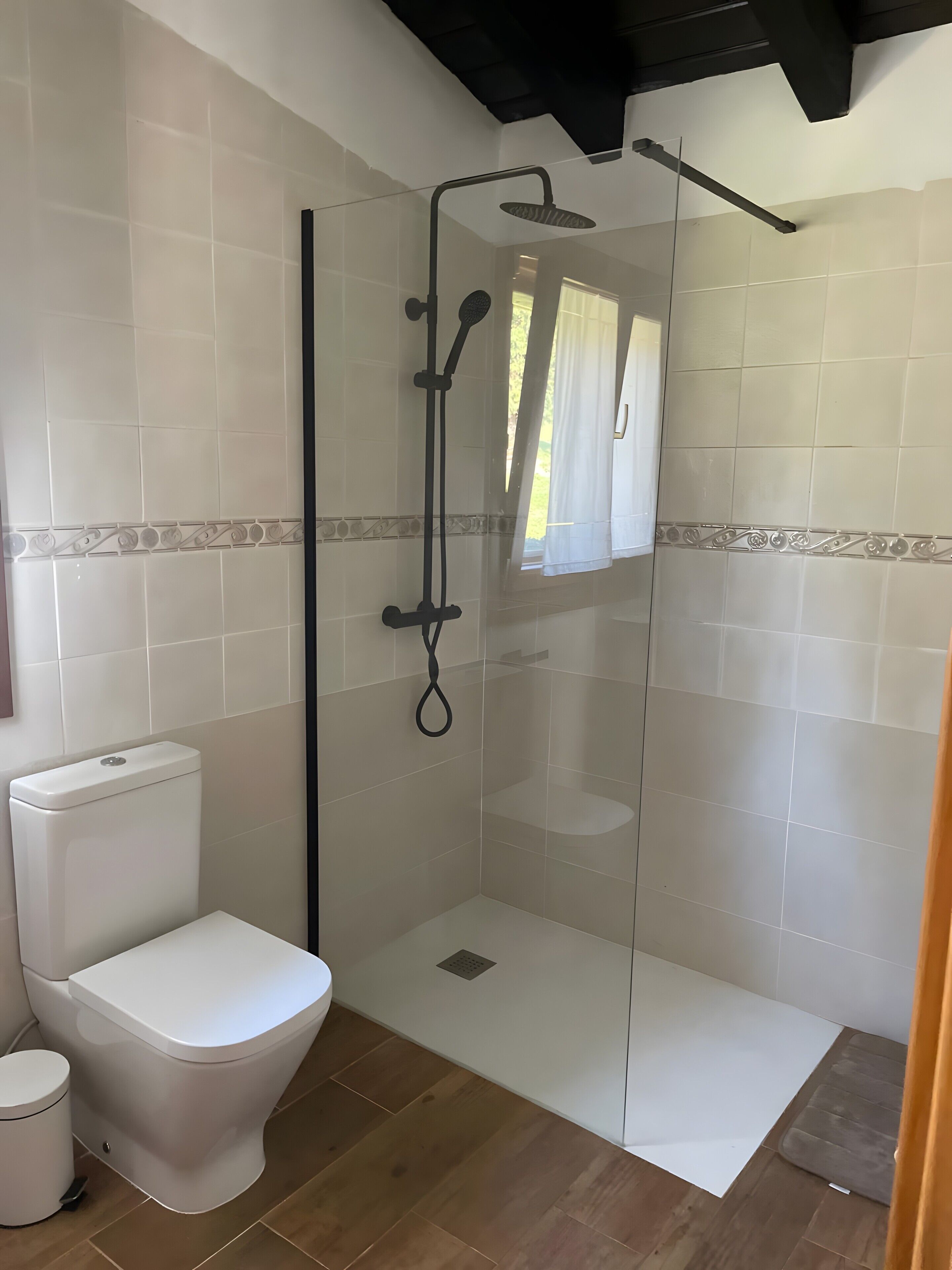 Un baño con ducha de vidrio, inodoro y bidé.
