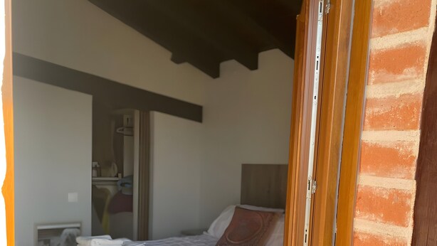 A bedroom with a bed, a nightstand, a wardrobe, and a bathroom visible through an open door. - Chalet 'Txatonea' with Mountain View, Private Terrace and Wi-Fi (Uribarri-Zabaleta)