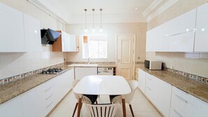 A modern kitchen with white cabinets, a granite countertop, a built-in microwave, and a window providing natural light.