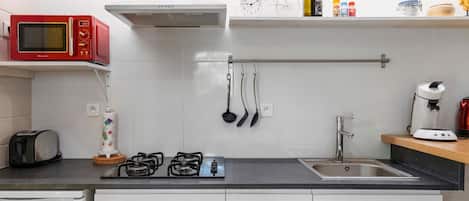 Cafetera o tetera, frigorífico, microondas y placa de cocina