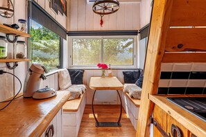 A compact kitchen with a window, a sink, and a stove. - La Tiny House De Peggy – mountain view, private terrace, and jacuzzi (Sisteron)