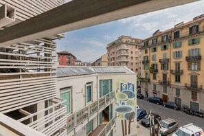 A multi-story building with balconies, a street view, and parked cars. - Priocca Mono 001 by Wonderful Italy (Turin)