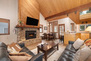 A spacious living room with a stone fireplace, leather sofas, and a wooden ceiling. - 3BR Cozy Townhome | Walk to Town | Office, Patio (Winter Park)