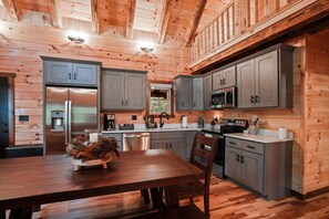 L’intérieur d’un chalet en bois comprend une cuisine, un coin repas et une fenêtre bien visible.