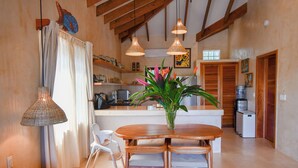 Une cuisine moderne avec des meubles en bois, une table à manger et des luminaires suspendus.