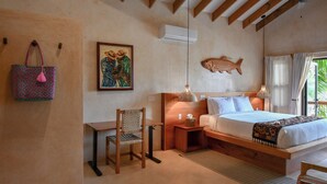 Une chambre avec un lit, un bureau, une chaise, un climatiseur, un décor mural représentant des poissons et un sac suspendu.