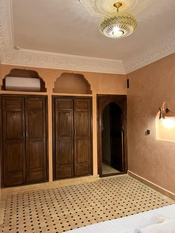 A room with a patterned floor, a bed, a wardrobe, and a mirror. - Dar Hilana Locanda Boutique Collection (Marrakech)