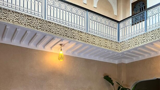 A pool area with a tiled floor, wooden chairs, and a lantern. - Dar Hilana Locanda Boutique Collection (Marrakech)