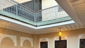 A spacious interior with a central open area, decorative arches, and a balcony with intricate railing. - Dar Hilana Locanda Boutique Collection (Marrakech)
