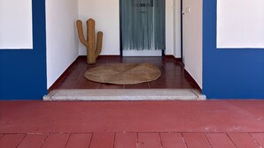 A doorway with a blue and white wall, a textured rug, and two cacti. - Country House 'Herdade Do Corval' with Mountain View, Wi-Fi and Air Conditioning (Regengos de Monsaraz)