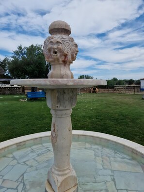 Una fuente con pedestal de piedra y cuenca circular.