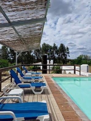 A poolside area with lounge chairs and a pergola.