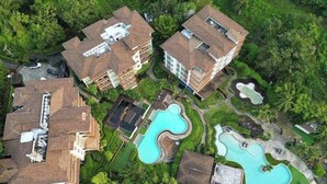 An aerial view of a resort with multiple buildings, swimming pools, and lush greenery. - F Shasa Vela Condominium (Koh Samui)