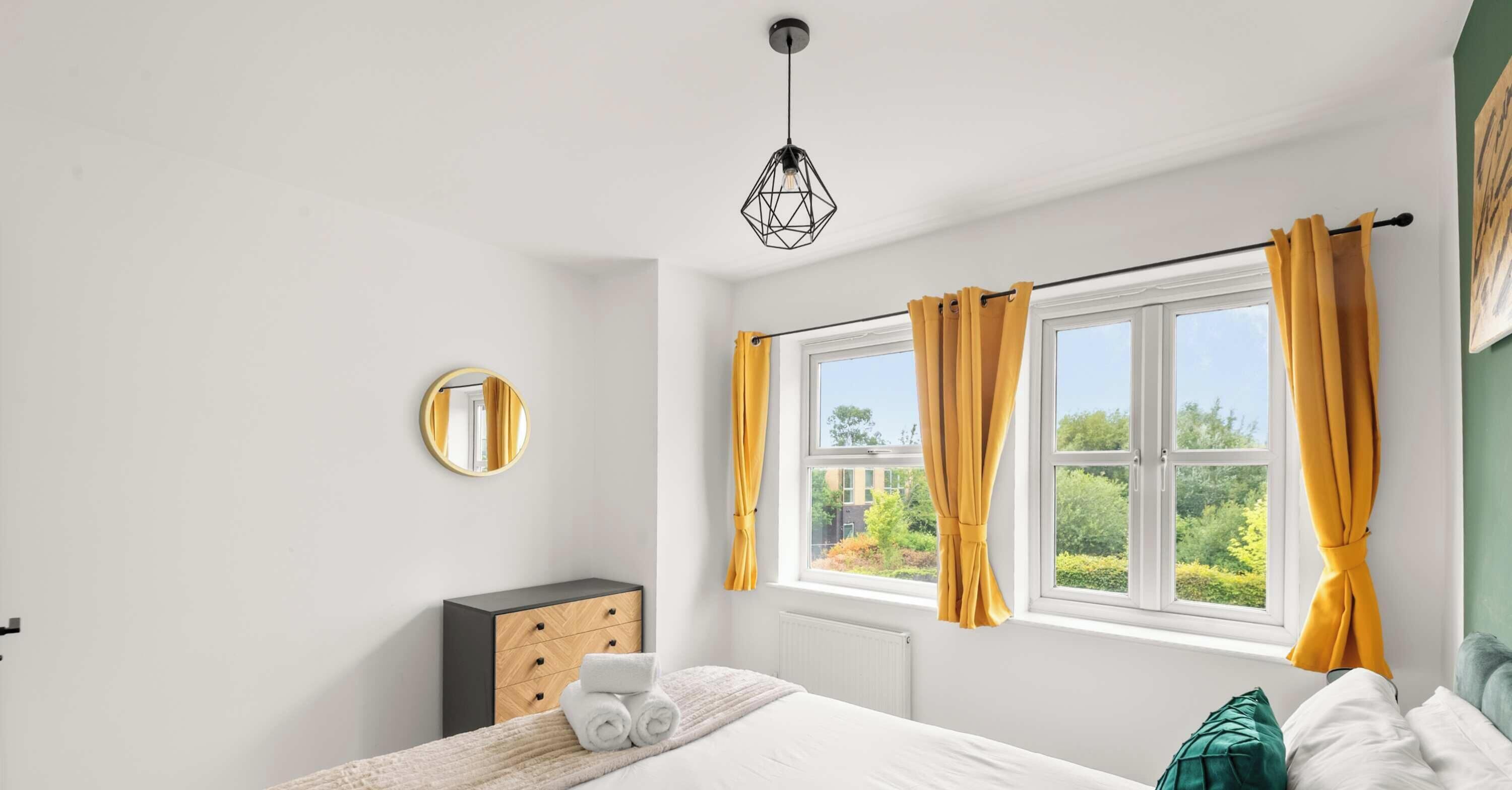 This bright and airy bedroom is perfectly designed to feel both modern and incredibly welcoming, especially with the natural sunlight pouring in through the large windows. The crisp white walls create a clean and spacious atmosphere.