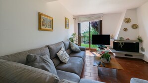 Ein Wohnzimmer mit einer Couch, einem Couchtisch, einem Flachbildfernseher und einem Kamin.