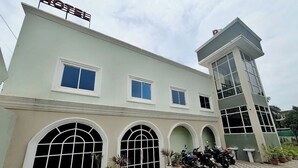 A hotel with a checkered pavement, large arched windows, and a sign indicating it is a hotel. - Hotel Dhana Lakshmi Bliss (Dewas)