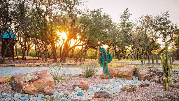 A desert garden with rocks, cacti, and trees during sunset. - Spacious 12-Bedroom Resort in Graham Texas  - sleeps 40 (Graham)