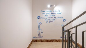 A staircase with a wall featuring a quote about love and flowers. - Guest House 'Sole e Amore' with Balcony, Wi-Fi and Air Conditioning (Casteldaccia)