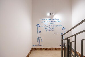 Un escalier avec un mur orné d’une citation sur l’amour et les fleurs.