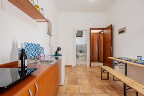 Une cuisine équipée d’un évier, d’une cuisinière, d’un banc en bois et d’un pare-feu en carreaux.