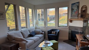 A modern living room with a sofa, armchairs, ottomans, a coffee table, and a fireplace. - Park City / Kimball Junction - 2-bed 2-bath Condo - Free Covered Parking, AC (Park City)