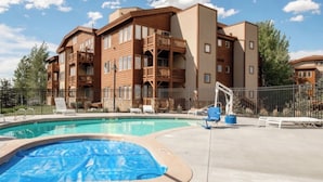 A hotel with a pool, outdoor seating, and a wooden facade. - Park City / Kimball Junction - 2-bed 2-bath Condo - Free Covered Parking, AC (Park City)