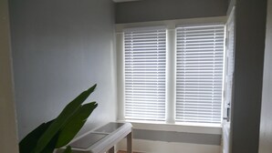 A room with a window, a bench, and a plant.