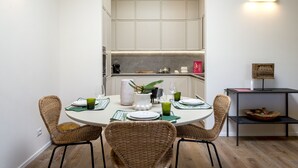 A dining area with a round table, four wicker chairs, and a central vase. - Olivuzza a Santa Margherita by Wonderful Italy (Santa Margherita Ligure)