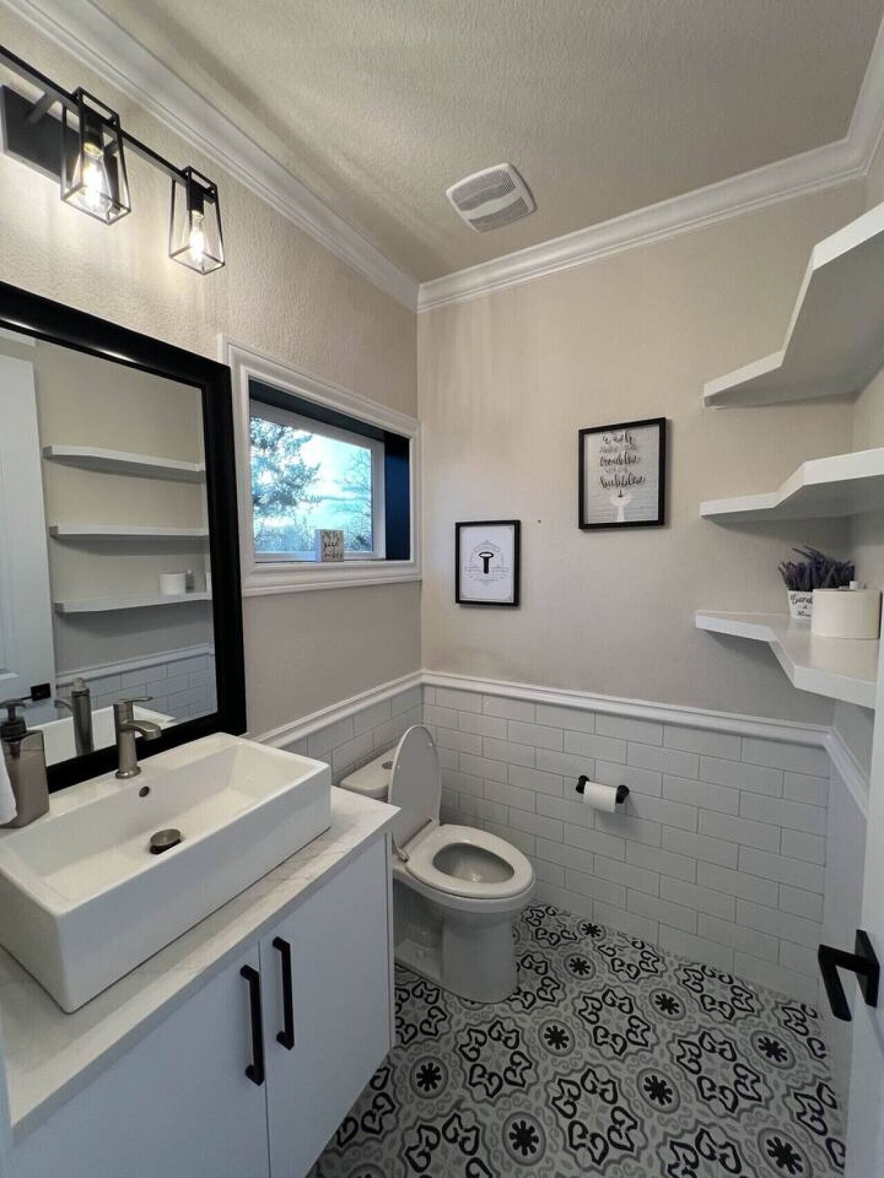 Ein Badezimmer mit Waschbecken, Toilette, Fenster und Spiegel.