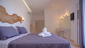 Een moderne slaapkamer met een groot bed, een houten decoratie aan de wand, een kaptafel met spiegel en een groot raam met gordijnen.