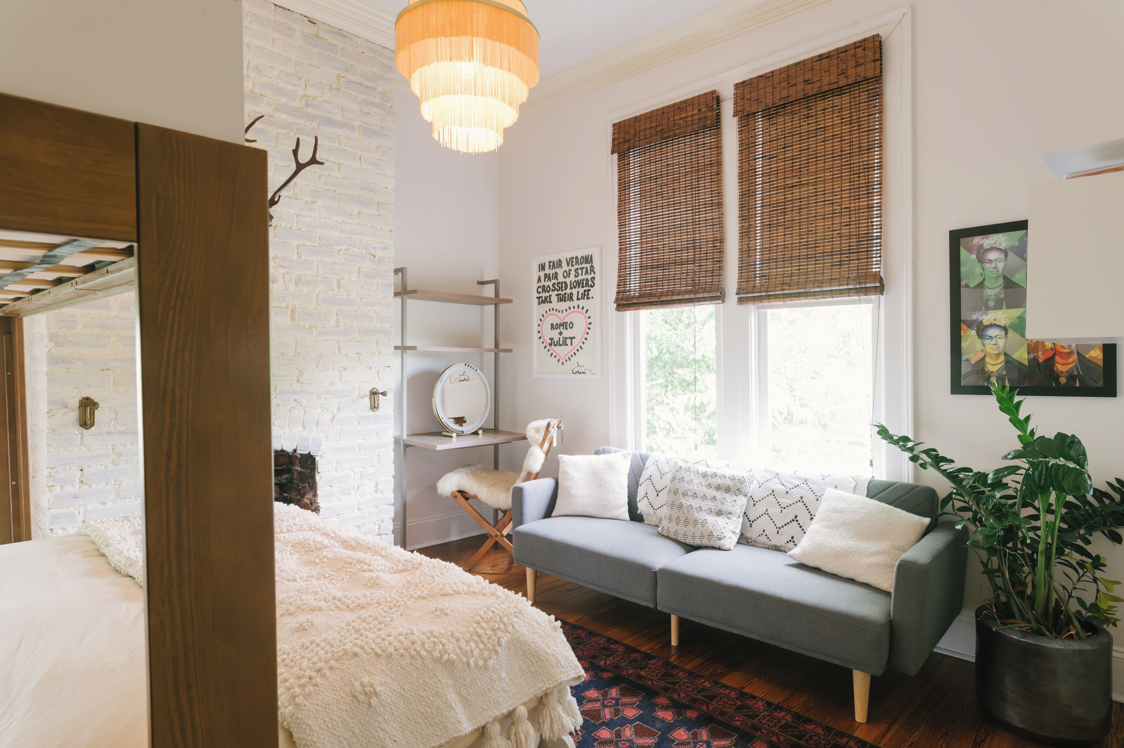 Una sala de estar acogedora con un sofá gris, un tapete blanco y suelo de madera.