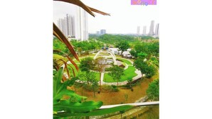 Vista de um terraço alto com vista para um parque com uma fonte, rodeado por vegetação e edifícios altos ao fundo.