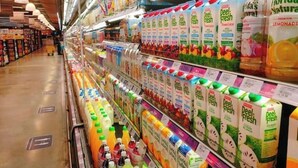 Um corredor de supermercado com diversas bebidas e produtos embalados.