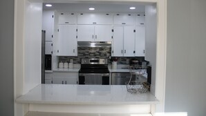 A compact kitchen with white cabinets, a stainless steel stove, and a tiled backsplash. - Spacious, Fully Remodel 4-bedroom house 2.5 bathroom in charming Carthage (Carthage)