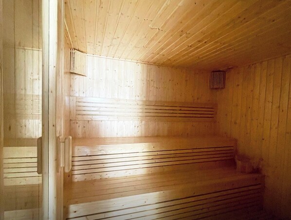 A sauna with wooden benches and a sloped ceiling. - 2 Bed Room Sea View Great Place (Pattaya)